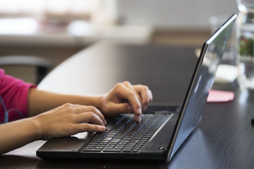 woman typing on laptop