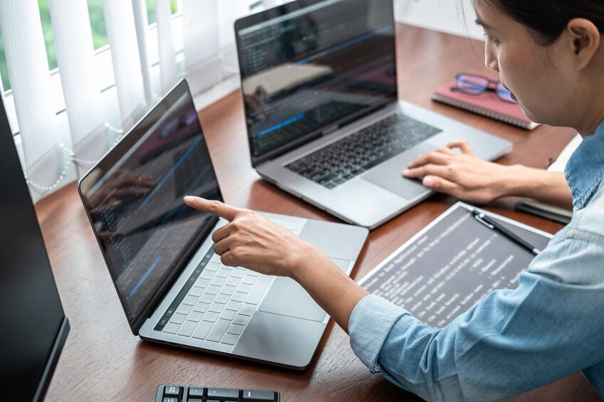 person looking at two different laptops