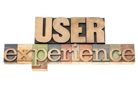 Blocks arranged to spell "User Experience" in a mix of uppercase wooden letters for "USER" and lowercase artistic letters for "experience".