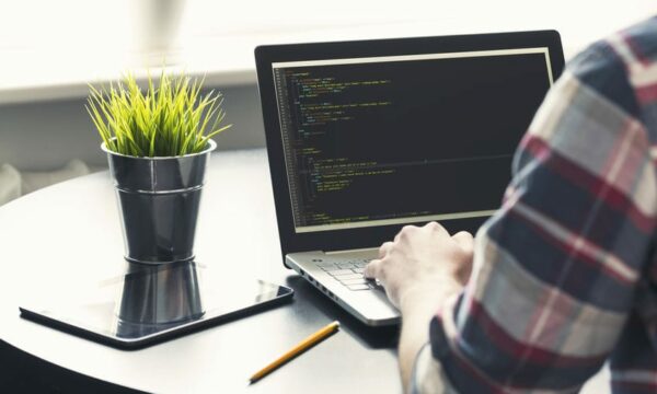 programmer working on laptop at office. focus on programming code