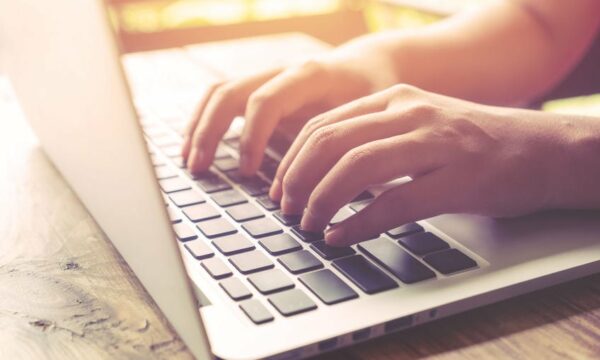 person typing on laptop keyboard