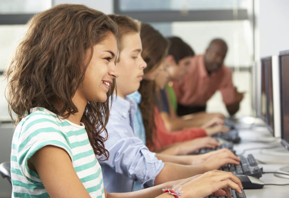 Group Of Students Working At Computers In Classroom