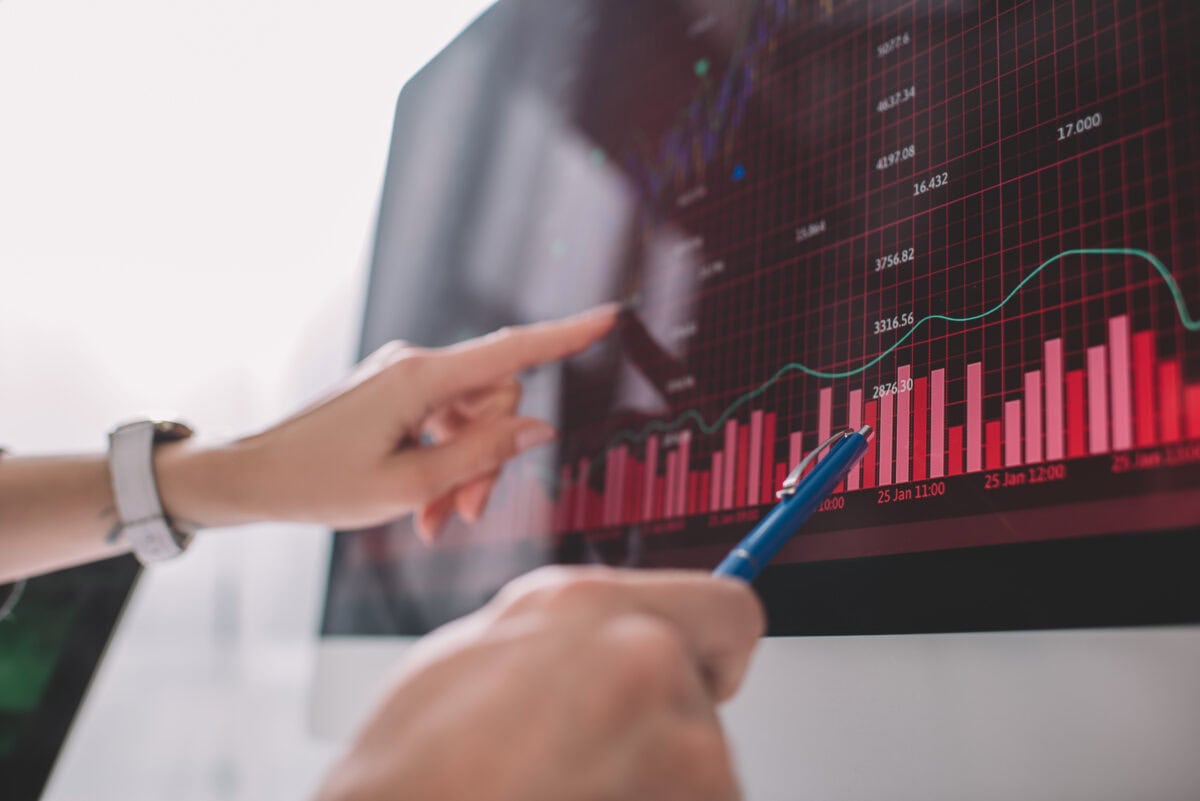 Selective focus of data analysts pointing on graphs on computer monitor while testing security of computer systems