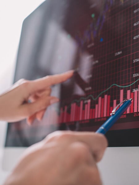 Selective focus of data analysts pointing on graphs on computer monitor while testing security of computer systems