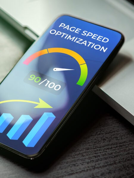 Mobile Page Speed Optimization concept. Website Loading Time image for internet SEO. Mobile phone lying on a black wooden table next to the laptop and on the screen accelerometer with high values