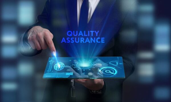 Futuristic hologram display saying "quality assurance" with a man in a suit pointing to it